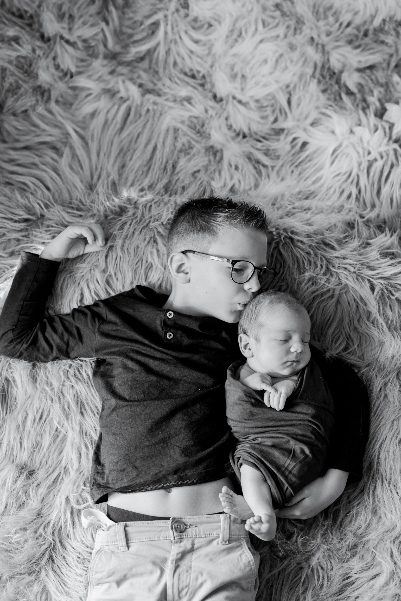 Deux enfants allongés sur un tapis.